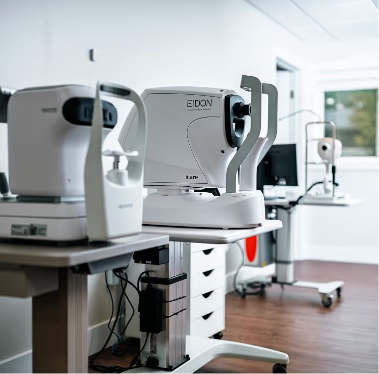Exam room with an auto refractor and a retinal imaging camera on two instrument tables