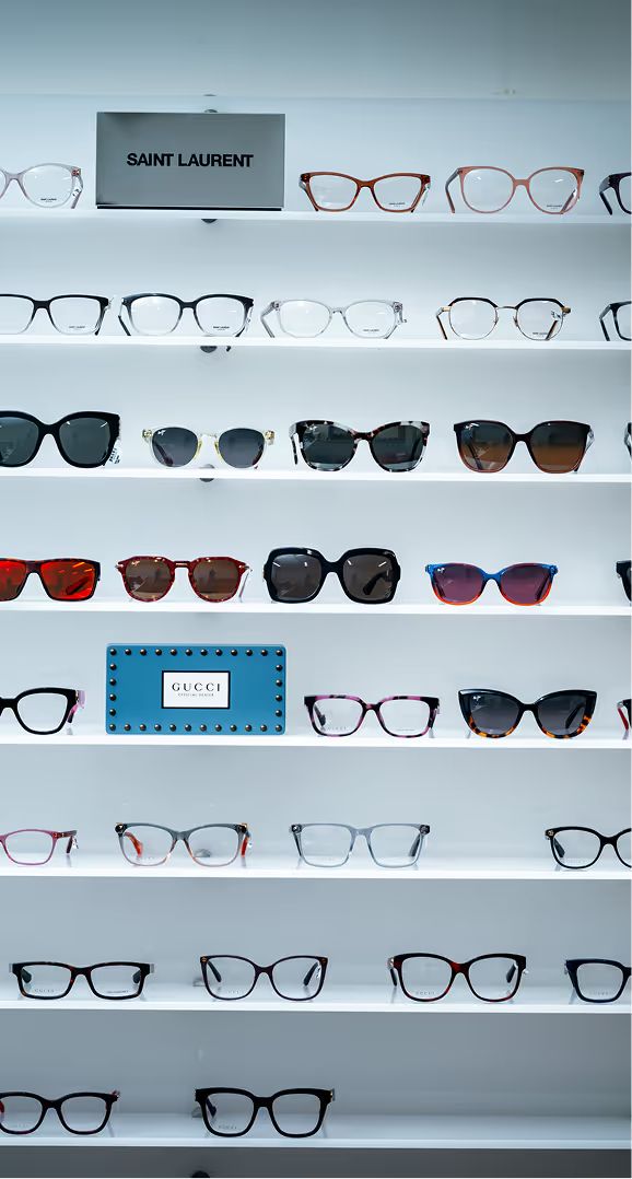 Wall display of eyeglasses and sunglasses on white shelves